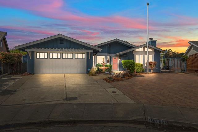 Front of house at dusk, flagpole, large parking area out front. 