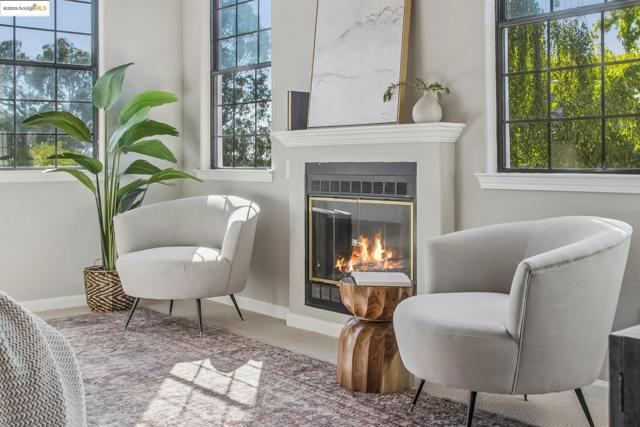 Living area with carpet flooring, a glass covered fireplace, and healthy amount of natural light