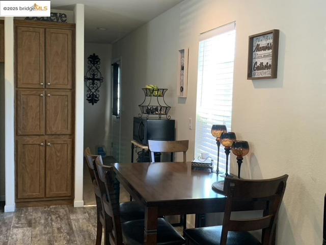 Dining area with dark wood-type flooring and baseboards