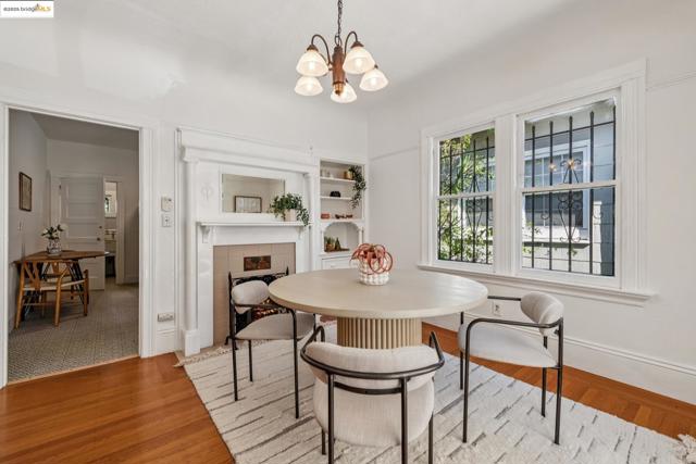 Dining area with a chandelier, light wood-type flooring, and a tile fireplace