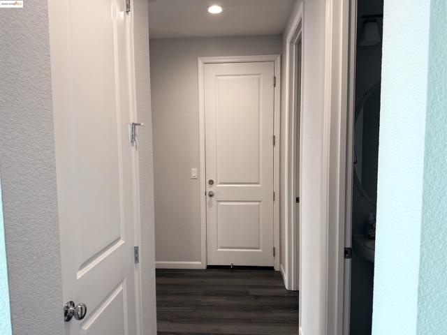 Hall featuring dark wood-type flooring and recessed lighting