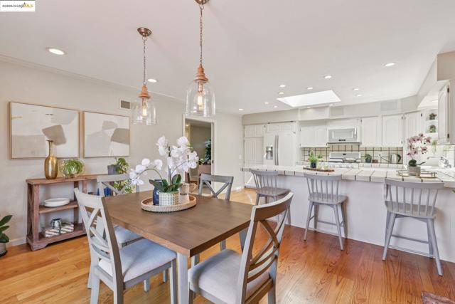 Dining area with a skylight, light wood-type flooring, recessed lighting, and ornamental molding