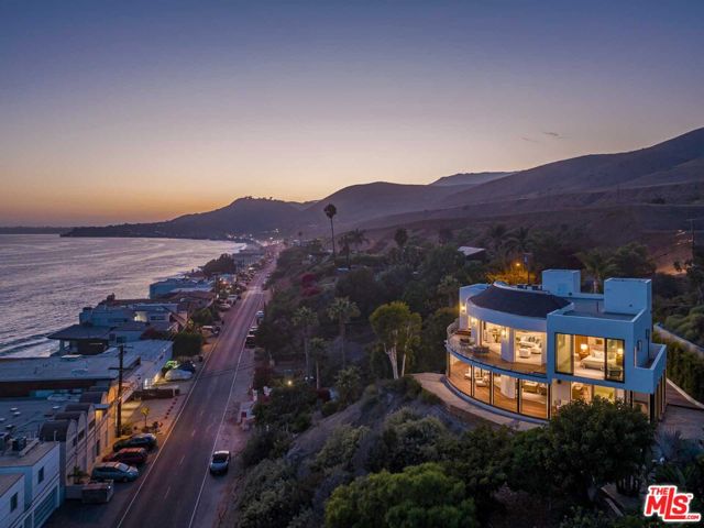 A divine modern retreat set above prime Malibu coastline, 25225 Malibu Road offers far-reaching ocean views plus seamless access to local conveniences. Designed by renowned architect Doug Burdge, this newly completed estate is replete with open-plan living spaces and entertainment-ready outdoor space. Inside the 3,254-SF, 2-level home, find a foyer with approx. 30-foot-tall ceilings, 3 all-ensuite bedrooms and 1 half bath, hardwood floors and walls of pocket, Fleetwood windows that encircle the estate and open to the main level wraparound deck and terrace with fire pit. The upper level encompasses a formal living room, a kitchen with Miele appliances, a glass-lined deck with whitewater ocean views and a primary suite with floor-to-ceiling windows and a spa-like bath. Additional features include a gated entry, an elevator, 4-car garage and driveway parking for up to 10 cars. 25225 Malibu Road is a short walk to Malibu's famed Malibu Road sandy beach, minutes from Little Beach House Malibu, Nobu, the Malibu Pier and Solstice Canyon hiking trails.