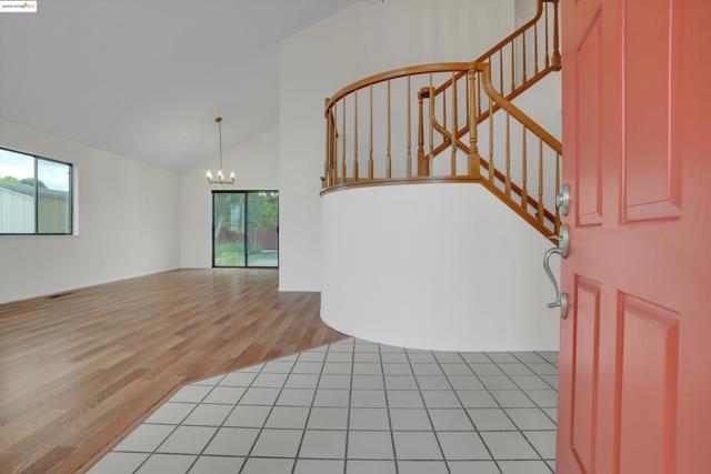 Entryway featuring plenty of natural light, high vaulted ceiling, a chandelier, light wood finished floors, and stairs