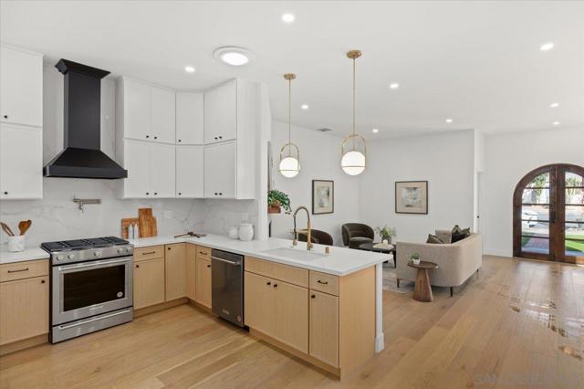 The gourmet kitchen boasts Quartz counters, stainless steel appliances including a french door refrigerator and 6 burner stove, sleek cabinetry, and a spacious pantry with a espresso station, perfect for culinary enthusiasts.