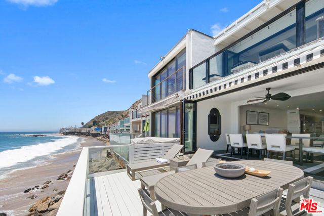 Located in Malibu on Big Rock Beach this beachfront property boasts a sweeping panoramic ocean view with expansive windows and beachfront decks that  captivate you from the moment you walk through the front door. There is an attached 2 car garage with additional street parking.  Remodeled with designer finishes, this two story, 2 bed/2.75 bath (3rd bedroom converted by previous owner to upstairs lounge) is updated throughout with the finest materials.  The spacious primary bedroom also has a private ocean view deck, custom closets and a gorgeous ensuite bathroom. Property is fee simple, land is owned.