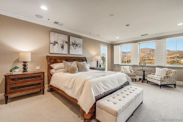 Spacious primary suite with stunning views, abundant natural light, and a cozy sitting area. Plantation shutters and elegant finishes create a serene retreat.