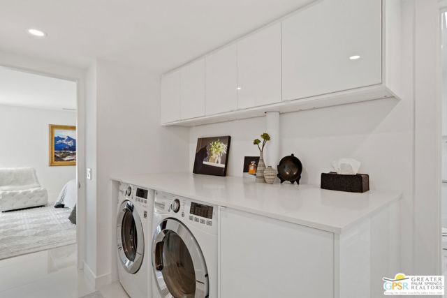 Indoor laundry with front-loading LG washer and dryer is conveniently located in the hall between the bedrooms.