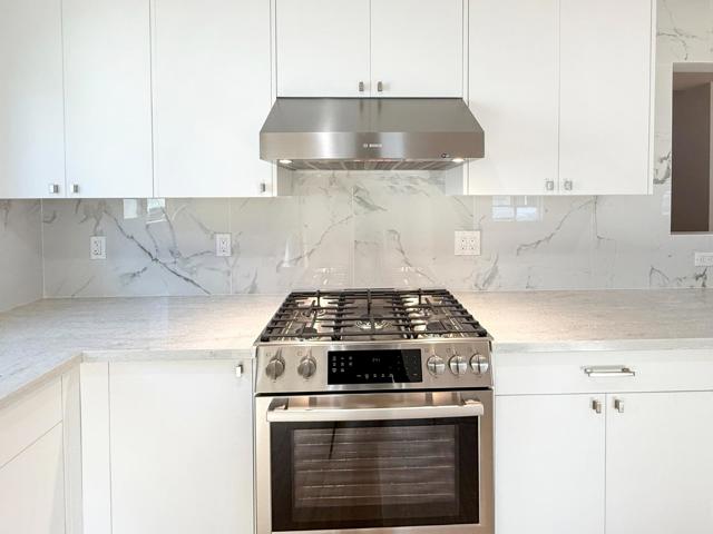 View Of Stove & Hood In Open Stadium Kitchen - 1st Floor
