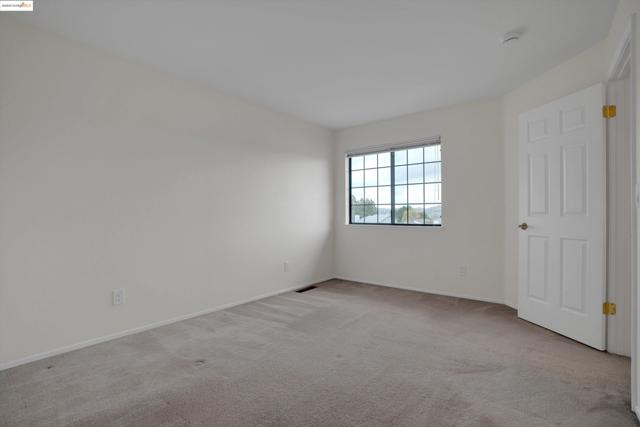 Spare room featuring light carpet and baseboards
