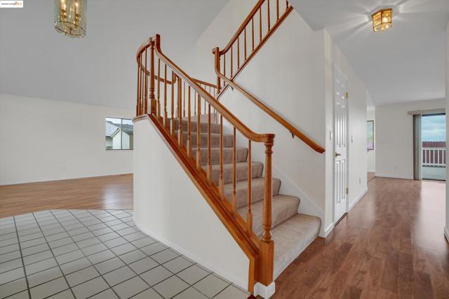 Stairs with wood finished floors and a chandelier