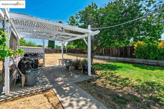 Fenced backyard with a pergola and a patio