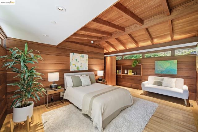 Bedroom featuring wood walls, light wood-type flooring, and wooden ceiling
