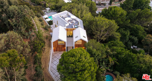 8070 Laurelmont Drive Los Angeles, California Welcome to "The Treehouse HH", an exceptional contemporary farmhouse conveniently nestled and privatized on a roughly acre flag lot within the iconic Mount Olympus neighborhood. You are welcomed from a long and impressive private and gated driveway encapsulated by ficus trees to a spacious motor court that can fit 6 cars, your 4-car garage, and two parallel and architecturally pleasing gabled volumes. Upon entry of "The Treehouse HH", you are welcomed and mesmerized by sophisticated design and an expansive open floor plan all encapsulated by gorgeous trees that truly make you feel one with nature. Enjoy memorable dinner parties in your chef's kitchen to die for or watch your favorite movie or TV show in your epic home theater. Ascend your staircase to your master suite w/ private balcony overlooking enchanting trees and LA city lights, master bathroom to die for, and spacious walk-in closet. Incredible lounge area on second level currently staged as a billiard & cocktail hangout room that can easily be converted into an epic home office, recording studio, production studio, gym, or other creative use. Ascend to your expansive rooftop deck w/ incredible city views, tree line views, and mountain views. Stroll outside to an entertainer's paradise including impressive features such as pool/spa, grassy area, BBQ area w/ outdoor bar, multiple lounge areas, and much more. Within close proximity to both Sunset Strip and Studio City's best restaurants, entertainment venues, shopping and nightlife via the infamous Laurel Canyon. Smart home technology throughout the home. Truly a rare architectural masterpiece that won't last long on the market.