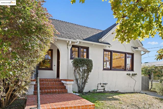 View of front of home featuring stucco siding and a shingled roof