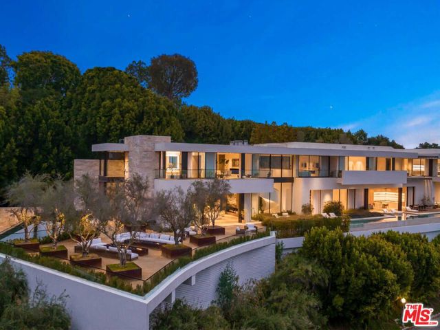 Ideally located in the most sought-after enclave of lower Bel Air, this 15,000 SF contemporary estate boasts spectacular unobstructed city-to-ocean views. Inside, a grand gallery-style hallway links each public room, creating a natural flow for entertaining. The main living spaces feature walnut wood floors, stone accent walls and include a great room, formal dining room, home theater and library. Additional features encompass a private wine cellar, a gourmet home kitchen and a separate chef's kitchen. A sunshine-filled sculptural staircase ascends to 5 guest bedrooms, the enormous primary suite, and a wellness center with travertine-clad steam room. Walls of glass throughout the home overlook breathtaking city views, a private infinity pool and spa, Ipe outdoor deck and gorgeously landscaped gardens. Perhaps the most stunning home feature is the 5,000+-SF rooftop terrace garden providing panoramic views of the city. All set minutes from the Bel Air Country Club and Beverly Hills.