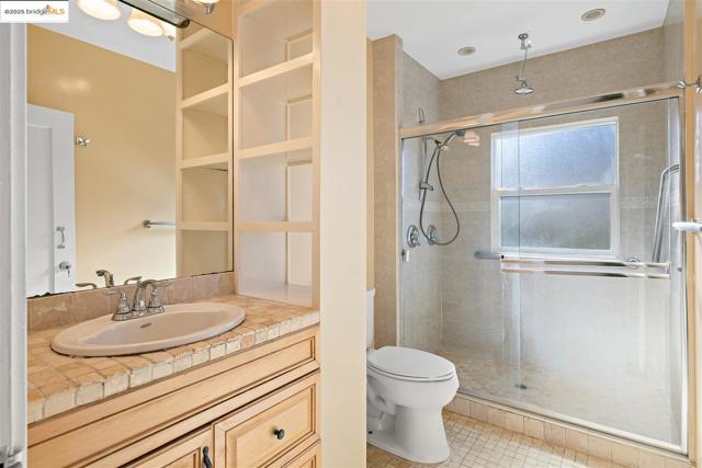 Full bathroom featuring vanity, a stall shower, and light tile patterned floors