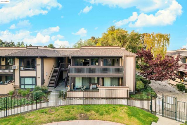 View of building exterior featuring stairs and a fenced front yard