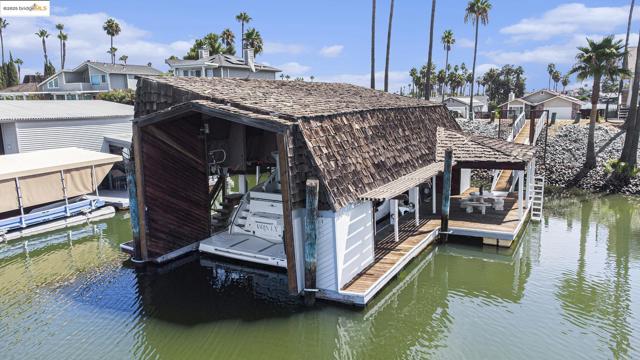 Dock featuring boat lift, a water view, and a residential view