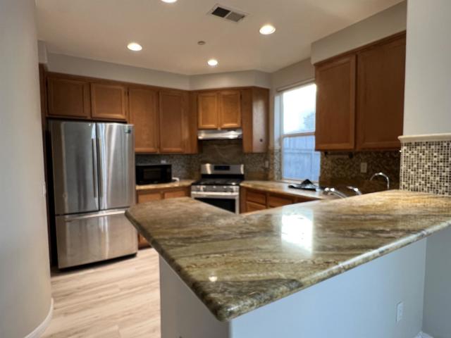 GRANITE TOP KITCHEN WITH CUSTOM BACK SPLASH AND S.S. APPLIANCES AS IS.