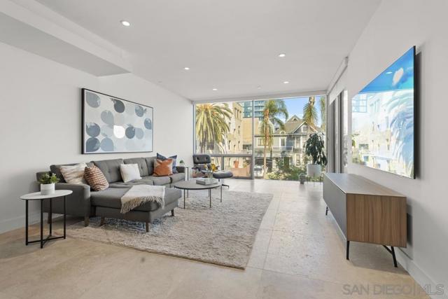 Living room featuring imported 24”x 36” Turkish stone tile flooring, floor to ceiling windows, an 85