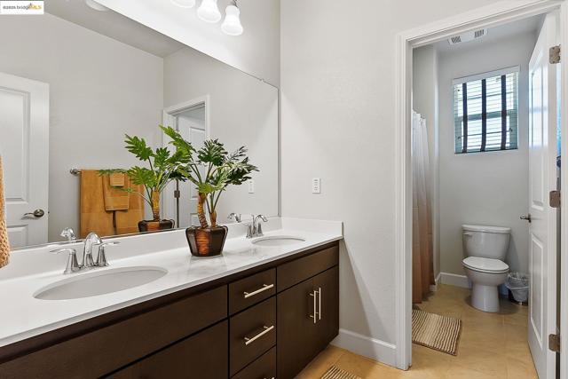 Full bath with double vanity, tile patterned floors, and a shower with curtain