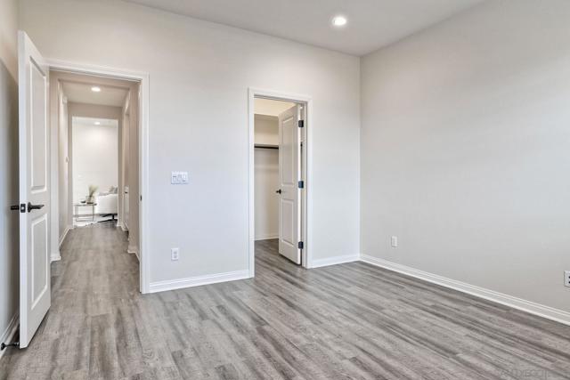 Secondary bedroom with walk in closet. View to the hall bath and loft area