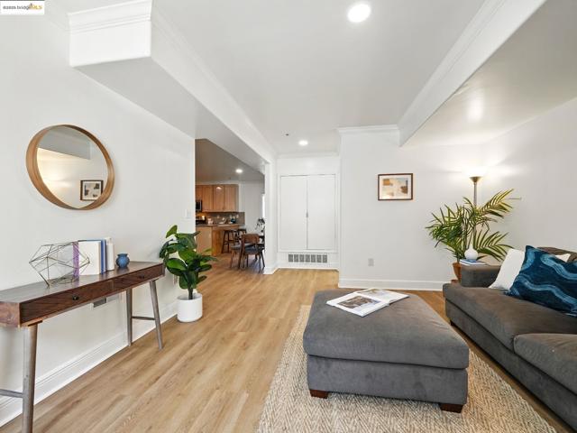 Living room with recessed lighting, ornamental molding, and light wood-style flooring