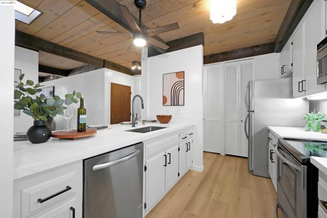 Kitchen featuring wooden ceiling, white cabinets, stainless steel appliances, a ceiling fan, and light wood finished floors