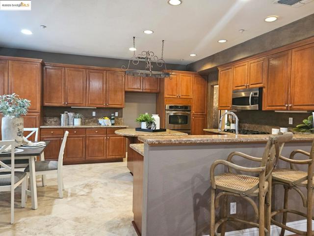 Kitchen with brown cabinets, a kitchen bar, a peninsula, and recessed lighting