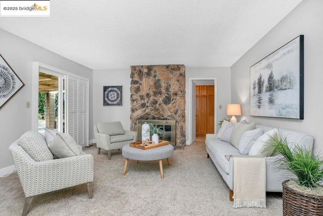 Living area featuring a fireplace, a textured ceiling, and carpet flooring