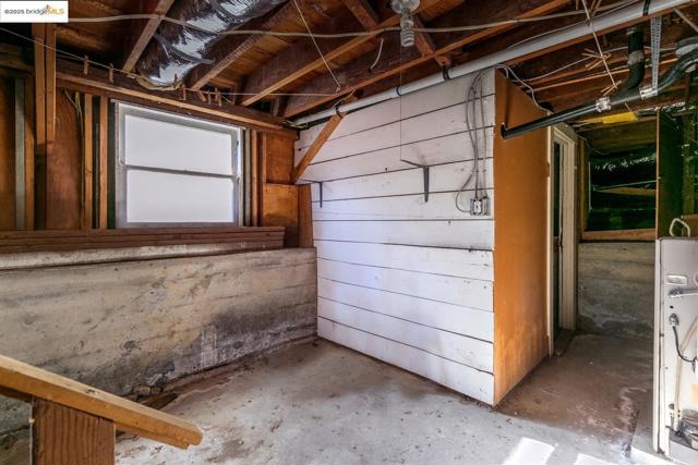 Basement featuring water heater and wood walls