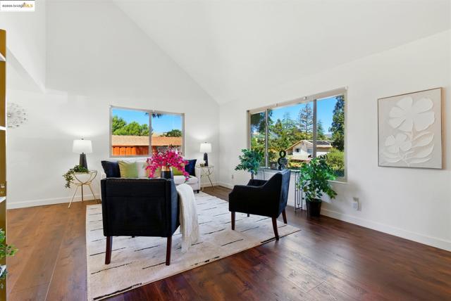 Living area with high vaulted ceiling and wood finished floors
