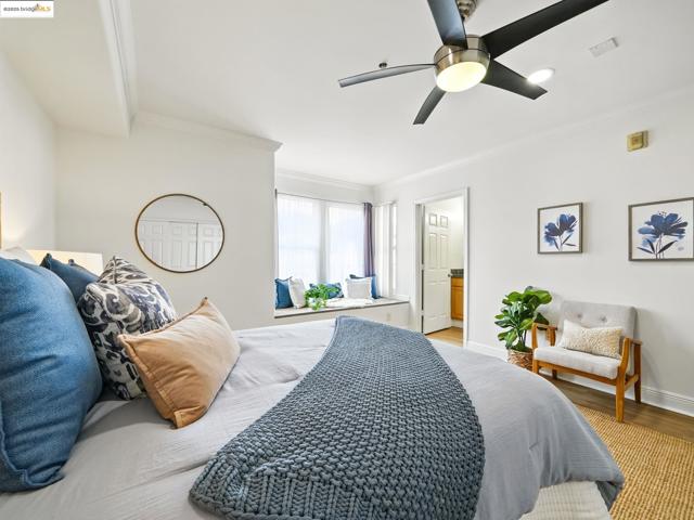 Bedroom featuring light wood-style floors, crown molding, and ceiling fan