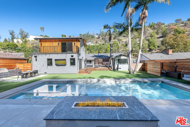 1551 Benedict Canyon Beverly Hills, California Stunning home in Beverly Hills locale, this coveted lower BHPO location is perfectly situated on a large lot with beautiful yard. This beautiful family home highlights the California lifestyle with indoor-outdoor living. A large panoramic door with over 12' of open, direct access from the living room leads to a gorgeous backyard retreat complete with ipe hardwood decking, large landscaped yard, brand new pool and spa, complete with safety cover and Septor 7, chemical free water system, custom BBQ, and a fire pit. This yard is perfect for entertaining and certain to get year round use. Enter the gate to a four-hole putting green, then walk into a beautiful open concept family room with views of the back yard, kitchen, dining area and breakfast bar over looking the back yard through a large picture window. The kitchen, complete with quartz counters, marble backsplash, a 36" SubZero Refrigerator and Freezer, providing 72" of refrigeration, Bertazzoni double wall ovens, Miele range top, pot filler and designer hardware is a cooks dream. A beautiful den connects to the five bedrooms, each with their own bathrooms. Downstairs, find the main master suite, with walk-in closet ensuite bathroom, complete with large walk-in shower, double shower heads and free standing tub. Two more bedrooms downstairs (one currently used as the playroom), and a laundry room complete the downstairs. Upstairs, a second master suite with a private balcony overlooking the yard, and another bedroom with ensuite bath complete this incredible interior of this home. The two-car garage has ample storage and a Tesla charger, ready for you to plug in and go!