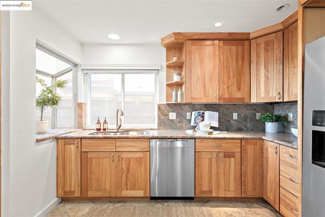 Kitchen with stainless steel appliances, open shelves, tasteful backsplash, brown cabinetry, and recessed lighting