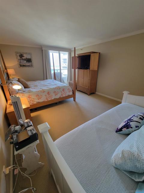 Large master bedroom has balcony access. Note the trundle bed in the foreground.