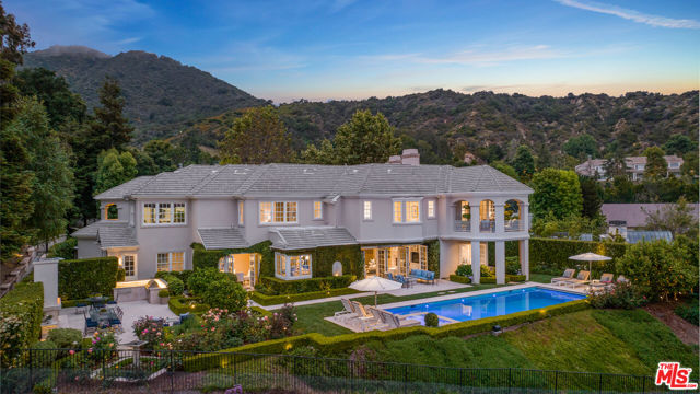 The rare opportunity to acquire a Pacific Palisades custom-built seven-bedroom, eight-bathroom traditional-style estate of this caliber is not often offered on the open market. This 7,401-square-foot home boasts five of its seven-bedroom suites, all on the upstairs level which is not common for Pacific Palisades. It is perfectly positioned on a fully landscaped half-acre boasting 126 feet of frontage and 146 feet along the rear of the property. Located in the highly desirable 24-hour guard-gated Palisades Country Estates, this is the perfect blend of security and privacy, yet close to town. With almost $1 million recently invested, the expansive reimagined backyard is like a 5-star resort. This entertaining paradise is defined by Durango Veracruz Travertine stone (quarried in Mexico) and a spectacular 20 by 40-foot pool and 10 by 12-foot spa complete with an automatic pool cover, elaborate underwater pool lights, and surrounded by in-ground Tucci umbrellas to relax poolside. The backyard also features an extensive custom LED lighting system and an elaborate concert-grade immersive sound system. Multiple seating areas are complemented by an under-lit stone fire pit, orange trees, and lavender.  An outdoor travertine fireplace with bench-style seating acts as an accent piece to a large formal dining area with an outdoor kitchen featuring a built-in Lynx gas grill, a warming oven, and oversized "L-Shaped" quartzite countertops. The rose garden, dual stone fountains, planting beds, and manicured lawn areas are all sub-irrigated. This is truly Provence in the Palisades. Elegant sophistication throughout this well-appointed classically timeless home is complimented by panoramic 180-degree vista views, allowing the perfect combination of indoor-outdoor living.  The home enjoys abundant natural light throughout that compliments the property's luxury lifestyle. From the grand formal entry with cathedral ceilings to a distinctive circular staircase leading to the upper level of private living spaces. Five well-appointed full-bedroom suites, including an expansive primary suite with a sitting room, and four additional bedrooms, share this upper level. In addition, there is a work-from-home office and a centralized homework station with custom built-ins. For added convenience, a second staircase leads downstairs to the kitchen, family room, and breakfast room where gracious French doors open to the lush, landscaped gardens. The main living area has two additional bedroom suites, a large, paneled library/ study, and a powder room. A great room perfectly positioned adjacent to the kitchen, featuring multiple French doors opening directly to the sprawling magical backyard. There is also a separate laundry room with a service entrance. The property also offers a 3-car direct entrance garage and ample driveway space for additional on-site parking. Moments away from this enclave are acclaimed public and private schools, a large park, a recreation center, and endless outdoor activities including hiking, mountain biking, beach days, and bike paths. The acclaimed Palisades Village is nearby with its award-winning restaurants for casual and fine dining, boutique shopping, the gourmet market Erewhon, a movie theater, and much more. This property has been impeccably maintained and has it all, from guard-gated security to the best of nature to all day-to-day conveniences one surely appreciates.