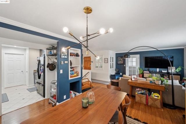 Dining space with ornamental molding, light wood-style flooring, and a chandelier