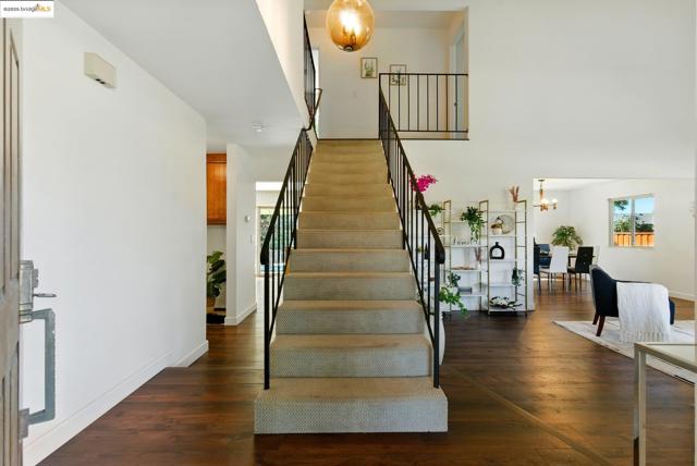 Stairway featuring a chandelier, wood finished floors, and a high ceiling