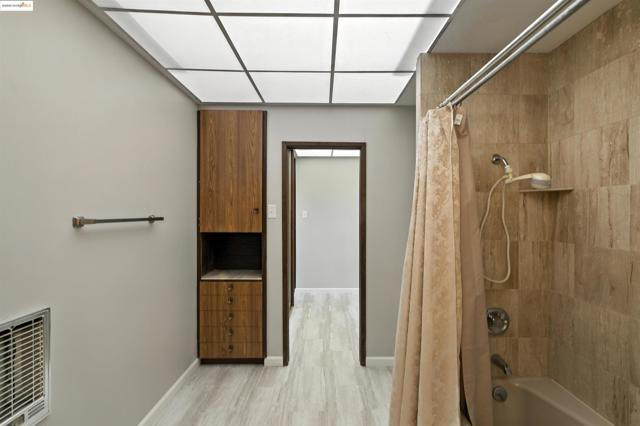 Full bath featuring shower / bathtub combination with curtain and wood finished floors