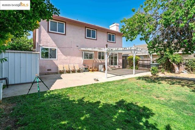 Back of property with a pergola, a chimney, a fenced backyard, a patio, and stucco siding