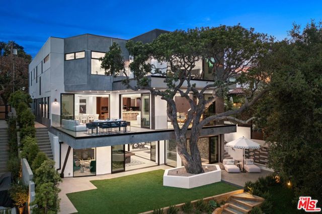 This extraordinary, new residence nestled in the Via Bluffs neighborhood of Pacific Palisades features spacious living, luxe amenities and an amazing outdoor space. Encompassing 7,448 SF, 6 beds and 7 baths, the home displays exquisite views of the Santa Monica Mountains and Potrero Canyon. The home facade is sleek and contemporary with elements of metal, concrete and glass. Inside, the desirable chef's kitchen has a gorgeous Cosentino island and large pantry. Attached is a chic living area with a gas fireplace and indoor/outdoor dining rooms. Opportunities to luxuriate abound with an indoor pool/spa, recreation room, theater and gym. Outside, find an enchanting, terraced yard with a custom fountain, BBQ bar and large deck. The primary suite features dual walk-in closets and a spa-like bathroom. Residents will enjoy a 2-car garage, two laundry rooms and an elevator. This pristine home beckons a life to live to its fullest, setting a scene of immaculate beauty and amenities.