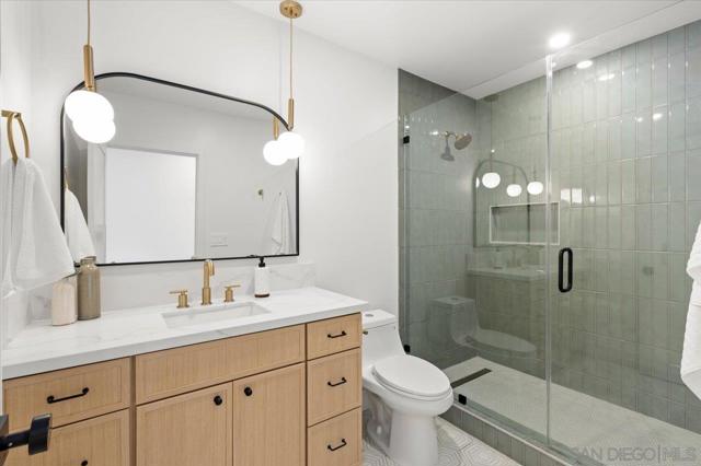 Large bathroom with full glass shower enclosure thoughtful lighting and luxury tile.