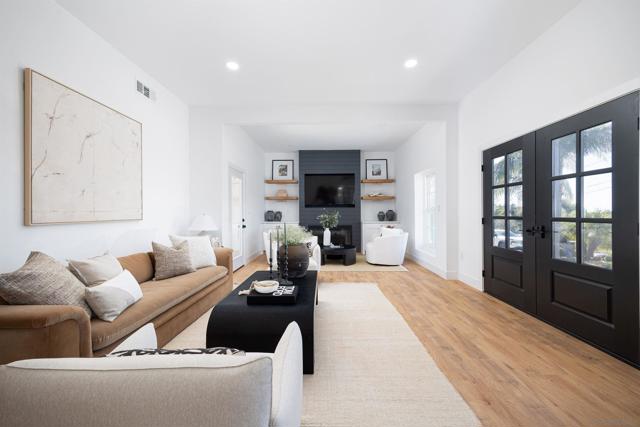 Large living room and entry area, custom fireplace with built in cabinets and floating shelves