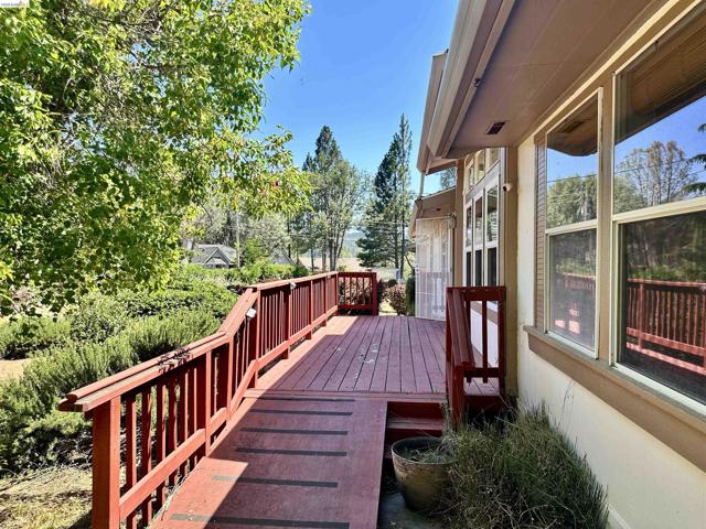 Expansive outdoor deck featuring a rich red finish, a ramp for accessibility, and a surrounding privacy railing