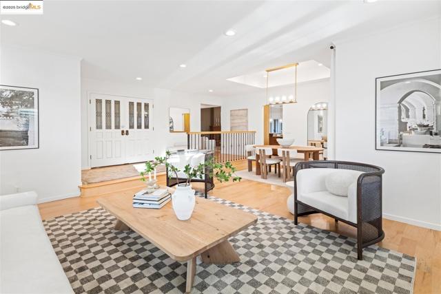 Living room featuring recessed lighting, a raised ceiling, and light wood finished floors