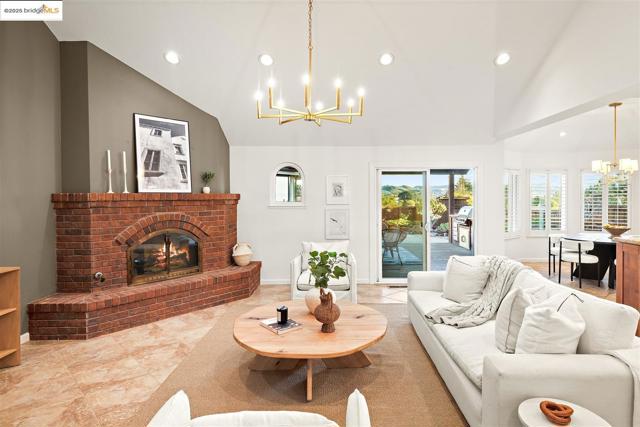 Tiled living area with a chandelier, a fireplace, recessed lighting, and high vaulted ceiling