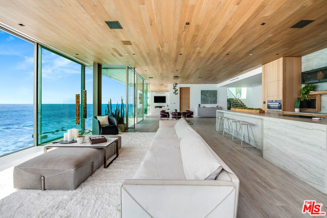 World class custom-built, all new Contemporary oceanfront masterpiece ideally located on famed Malibu Road beach. Set on approximately 100 feet of pristine sandy beach frontage with private gated beach access and a coveted private pool and spa. Fire pit and additional spa on the Ipe wood rooftop deck. Push a button and the walls of glass disappear leaving only the glass railings between you and the Pacific! Wide open concept design leads you to view the tide pools or the surfer's beyond! With over 5,000 sq.ft. of living space, this home offers fine artisan custom finishes throughout including walnut wood interior cabinetry, heated Italian porcelain floors, Smart home Control 4 home automation, state of the art Lutron lighting system, Dornbracht and Fantini plumbing fixtures, Miele top-of-the-line appliances, and Quartzite kitchen and bathroom countertops. Built on 27 caissons that go 60 feet deep and are anchored to solid bedrock. The master bedroom and main floor capture unobstructed ocean vistas. Watch the coast light up at night and the "Queens necklace" view sparkle! This prime location allows for easy access and close proximity to some of the finest restaurants, shopping, and entertainment in all of Malibu. This impressive and immaculate oceanfront estate embodies California living at its absolute finest.