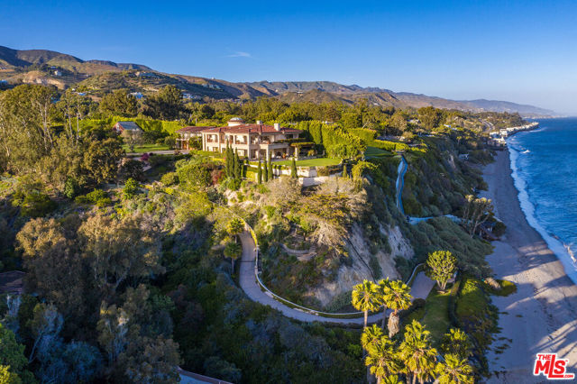 Discover absolute nirvana in this World-Class Oceanfront Estate situated on over 3.5 acres on the coveted Paradise Cove bluff. Located on one of the most private and ideal sections of the bluff and one of the most secluded and sought-after beaches in Malibu, this property offers its own private pathway to over 208 feet of sandy beach frontage and breathtaking coastline and ocean views. Enter through the private front gate to the long driveway that winds past the tennis court, detached guesthouse, and expansive lawns and leads to the graceful two-story main house. This gorgeous Villa offers a casually elegant style and peaceful ambiance with walls of pocketed glass doors throughout that open to large terraces encircling the home and allowing the light-filled interior to integrate with the lush exterior and enveloping ocean vistas. The main floor features a formal foyer, living room with fireplace, dining room, screening room, and tremendous gourmet kitchen with professional appliances, huge island, breakfast room, and walls of glass that open to an outdoor dining terrace. The upper level features 4 bedroom suites including the magnificent master suite complete with fireplace, luxurious bathroom, custom large walk-in closets, and private terrace overlooking the stunning ocean views. Staff quarters with kitchen are located off the three-car garage, while above the garage there are two guest bedroom suites, each with lovely bathrooms and terraces, and one with a kitchenette. The second detached guesthouse located adjacent to the tennis court features a living room, bedroom, three bathrooms, and a large upper level with vaulted ceilings currently used as a gym, ballet and yoga studio. This exceptional oceanfront compound offers the ultimate resort lifestyle located on one of the most incredible bluffs and beaches in the world.